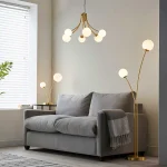 Floor lamp in brushed gold finish with white glass shades