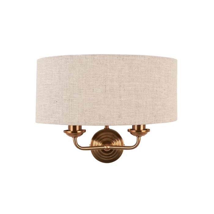 Wall light in aged brass finish with natural linen fabric shade