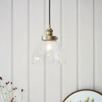 Single pendant light in antique brass finish with clear glass shade