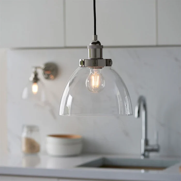 Single pendant light in bright nickel finish with clear glass shade