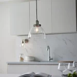 Single pendant light in bright nickel finish with clear glass shade