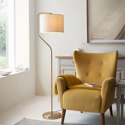 Floor lamp in brushed aged brass finish with natural linen fabric shade