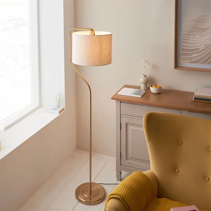 Floor lamp in brushed aged brass finish with natural linen fabric shade