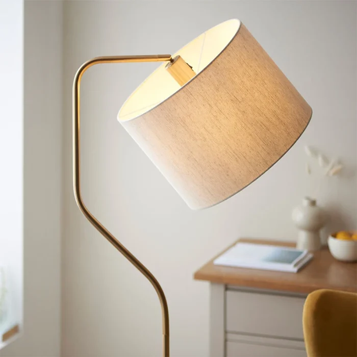 Floor lamp in brushed aged brass finish with natural linen fabric shade