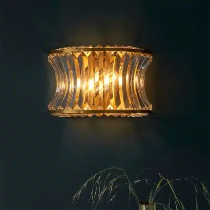 Wall light in brushed warm brass finish with clear glass