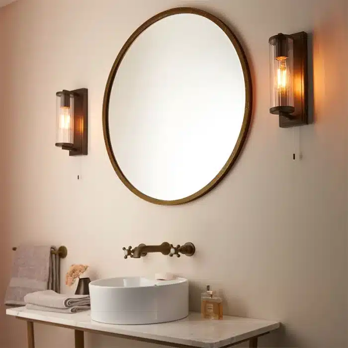 Bathroom wall light in dark bronze finish with clear glass shade