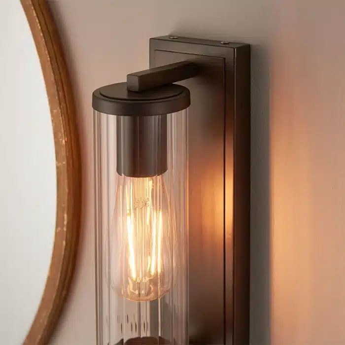 Bathroom wall light in dark bronze finish with clear glass shade