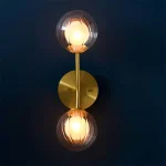 Wall light in satin brass finish with clear ribbed glass